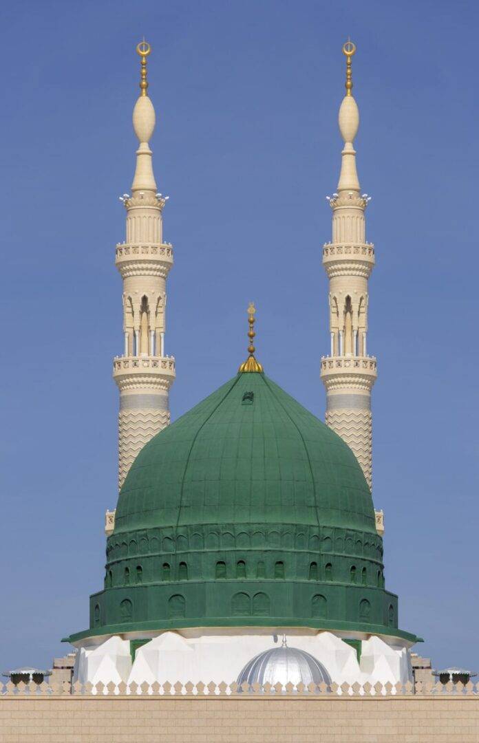 Photo of the Prophet Muhammad's mosque in Medina,with two tall minarets and a green dome