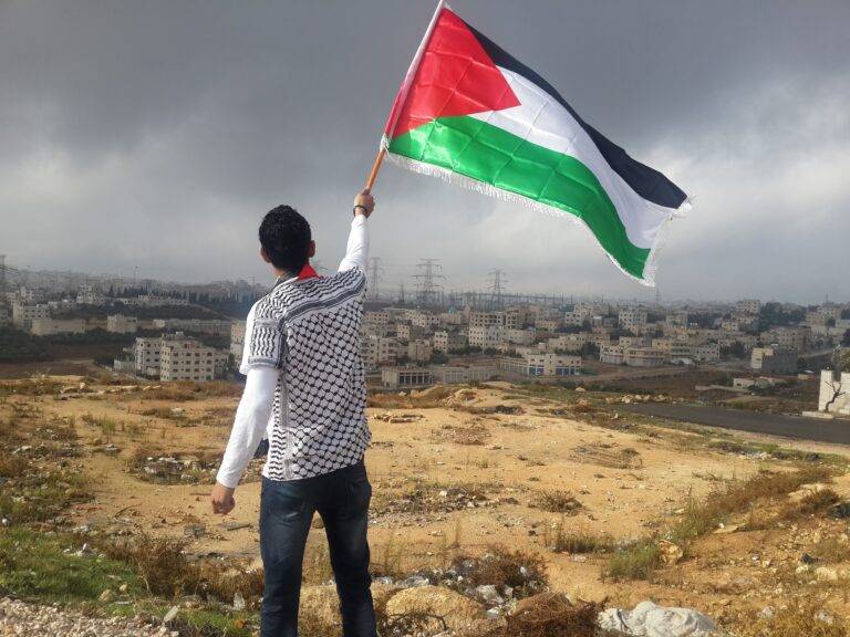 Palestinian man holds a Palestinian flag.